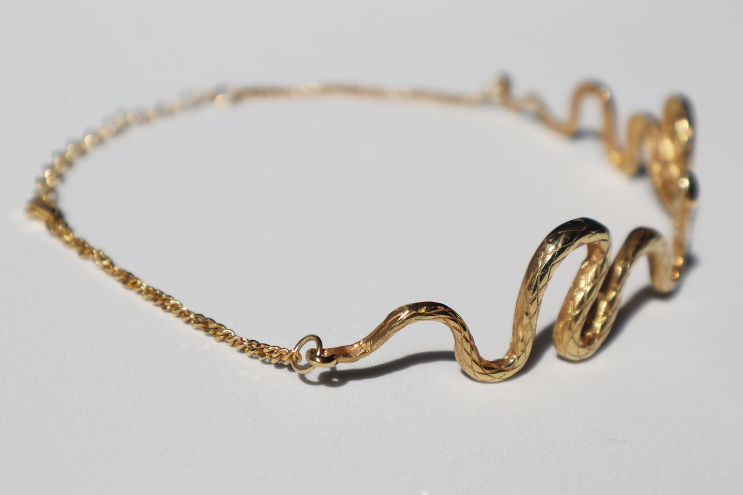 The Kunda Chocker resembles a snake unfolding on your neck, as a symbol of the Kundalini Awakening, reaching the Throat Chakra. Elegant and modern gold wavy snake chocker.